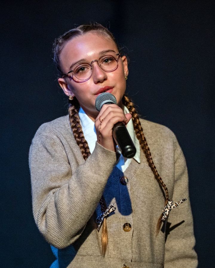 Thya qui chante sur scène, micro à la main
